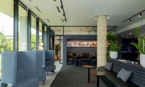 a lobby with blue furniture and a restaurant at Modern Tampa Studio Near Ybor City & Downtown in Tampa