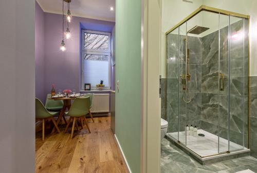 a bathroom with a shower and a dining room with a table at FABEL Apartments am Hbf in Berlin