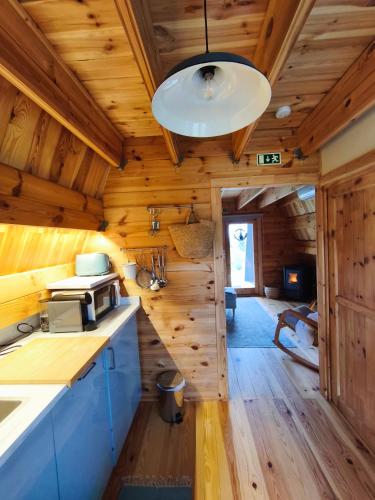 a kitchen with wooden walls and a ceiling at Chalé da Cumieira Nova in Seia