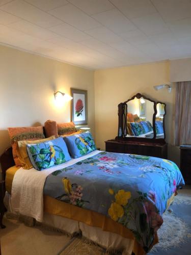 een slaapkamer met een bed en een grote spiegel bij Coppelia Sunrise in Omokoroa