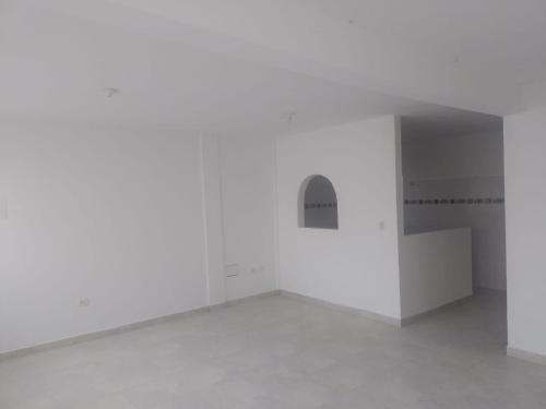 een lege kamer met witte muren en betonnen vloeren bij Barbara León in Simacota