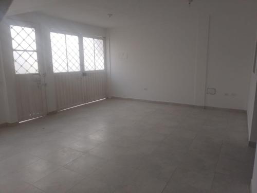 een lege kamer met witte muren en ramen bij Barbara León in Simacota
