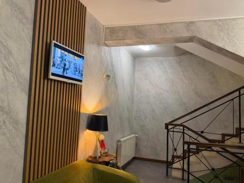 een woonkamer met een trap en een groene bank bij Family Hotel Lazur in Bansko