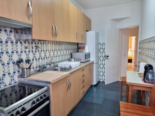 una cucina con mobili in legno e un lavello di Happy House - Central Apartment a Faro