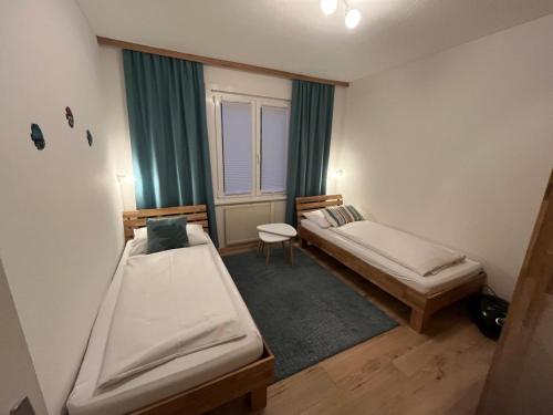 een kleine kamer met twee bedden en een raam bij Ferienhaus mit Sauna direkt am Ossiacher See und an der Gerlitzen Alpe in Bodensdorf