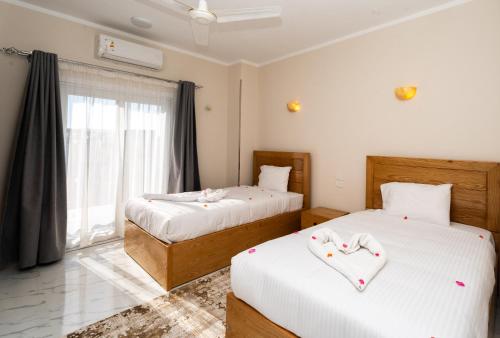 a bedroom with two beds and a window at Villa Ramses in Luxor
