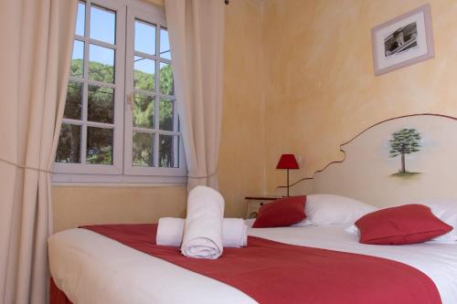 two beds in a room with two windows at Hôtel & Spa La Villa in Sainte-Maxime