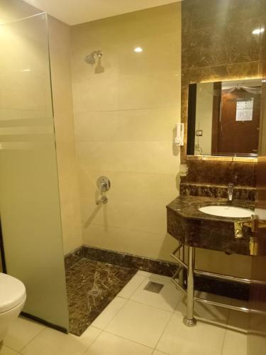 a bathroom with a sink and a shower and a toilet at فندق الكشاف المتقدم توصيل للحرم مجاني in Mecca