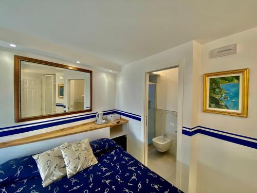 a bedroom with a blue bed and a mirror at Giovanni Rooms Manarola in Manarola