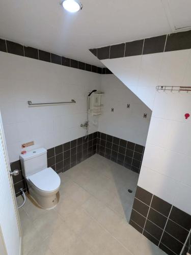 a bathroom with a toilet and tiled walls at Number 1 Guesthouse in Ao Nang Beach