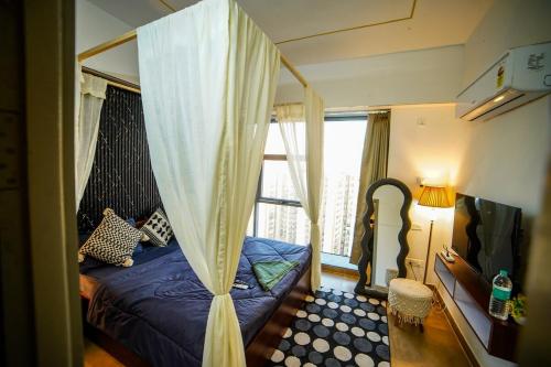 a bedroom with a canopy bed and a window at Lux 1bhk with balcony in Noida