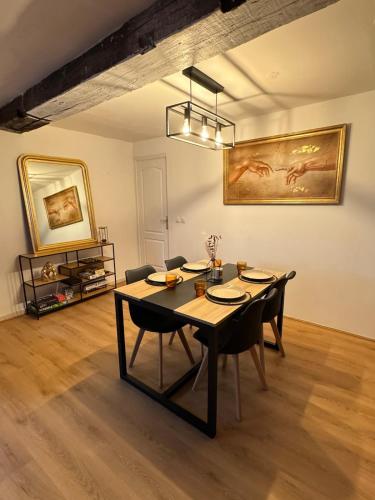 una sala da pranzo con tavolo e sedie di Cozy - Cœur de Ville a Valenciennes