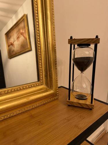 un orologio su un tavolo accanto a un quadro dorato di Cozy - Cœur de Ville a Valenciennes