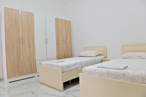 a bedroom with two beds and a wardrobe at Ferienhaus Qelia in Durrës