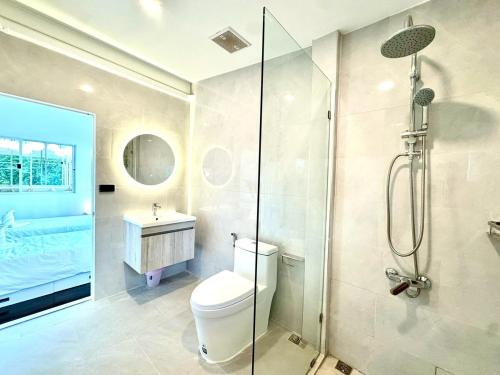 a bathroom with a shower and a toilet and a sink at Sunset Beach Villa 30m to Beach 4BR in North Pattaya