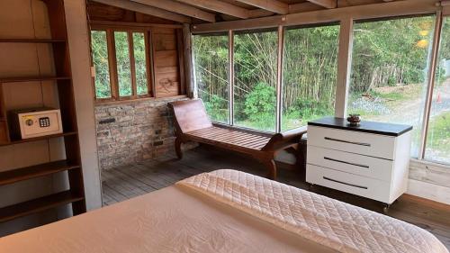 een slaapkamer met een bed en een stoel in een hut bij Chalé da Joaquina in Florianópolis