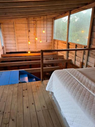 a bedroom with a bed in a wooden cabin at Chalé da Joaquina in Florianópolis