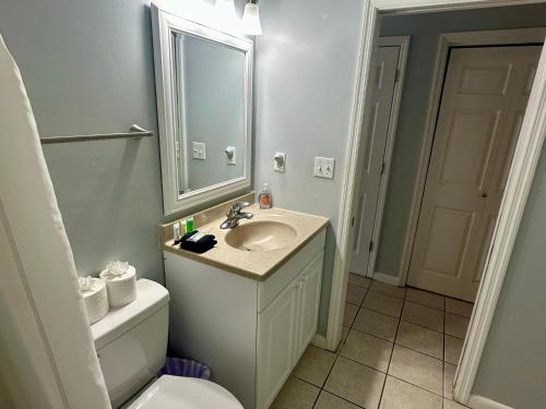 a bathroom with a sink and a toilet and a mirror at Seaside 249 in Hilton Head Island