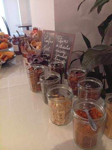 une table recouverte de bocaux de nourriture dans l'établissement BRIT HOTEL Le Lion d'Or CHINON, à Chinon