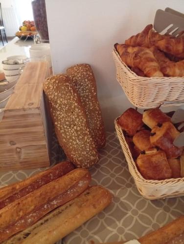 une table avec des paniers de pain et des paniers de viennoiseries dans l'établissement BRIT HOTEL Le Lion d'Or CHINON, à Chinon