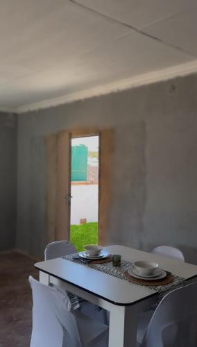 a table and chairs with plates on top of it at Amai Guesthouse in Thohoyandou