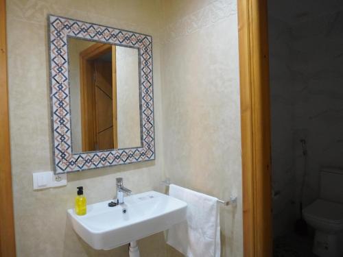 ein Badezimmer mit Waschbecken, Spiegel und Toilette in der Unterkunft Shams house in Imsouane