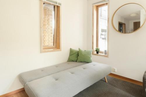 een bank in een kamer met een spiegel bij Stylish apt 2nd floor city centre in Trondheim