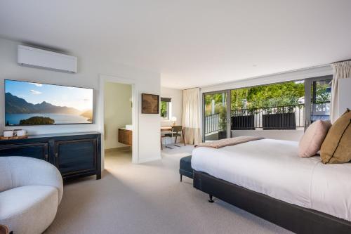 a bedroom with a bed and a large window at Limerick- Fire Place- Lake Views- BBQ- AC in Queenstown