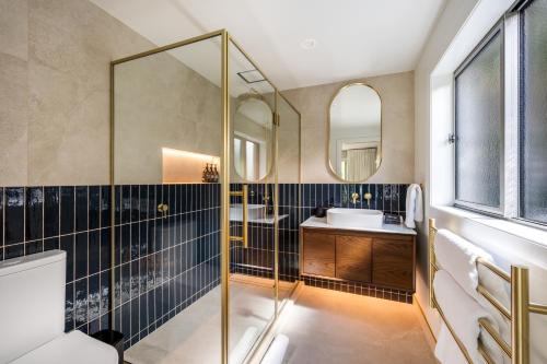 a bathroom with a glass shower and a sink at Limerick- Fire Place- Lake Views- BBQ- AC in Queenstown