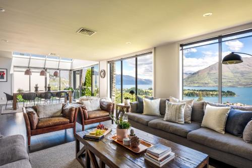 a living room with a couch and a table at Limerick- Fire Place- Lake Views- BBQ- AC in Queenstown