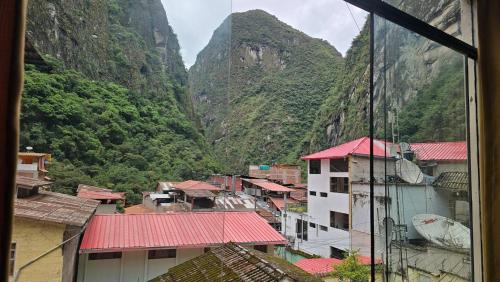 ein Blick auf eine Stadt mit Bergen im Hintergrund in der Unterkunft Hostal Mónaco in Machu Picchu