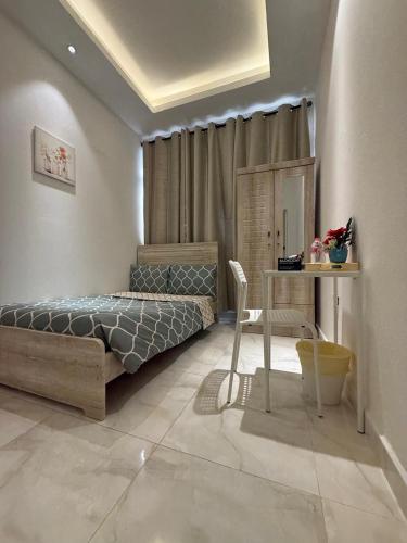 a bedroom with a bed and a table and a desk at Emira Property in Abu Dhabi