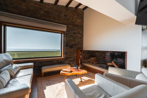 een woonkamer met een bank en een open haard bij Dunéa - Oceanfront Luxury and Serenity - Ofir in Esposende