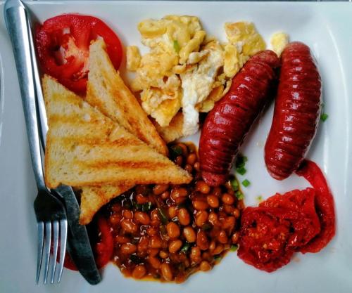 ein Teller mit Hotdogs, Bohnen und Toast in der Unterkunft Ngami Gates Boutiqúe Guesthouse in Maun