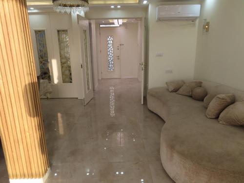 a living room with a large couch and a hallway at Gedera Rental in Gedera