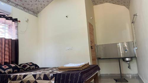 a room with a bed in a room with at Stone Guest House Gokarna in Gokarn