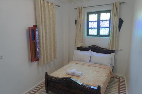 een kleine slaapkamer met een bed en een raam bij Riad Dalal in Fès