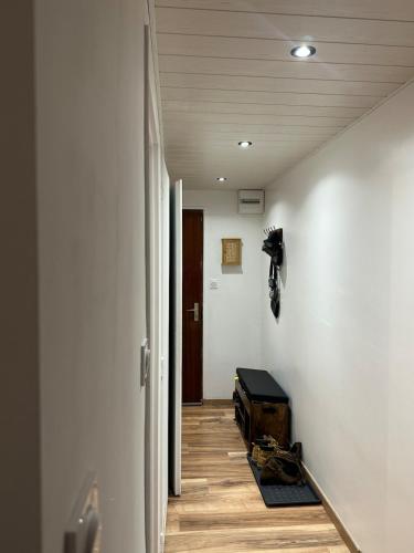 - un couloir avec des murs blancs, du parquet et une porte dans l'établissement Le Nid des Pistes, à Métabief