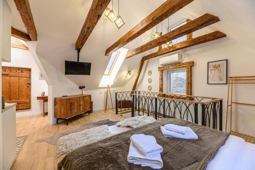 a bedroom with a large bed in a room with wooden ceilings at Republicii Residence in Braşov