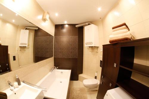 a bathroom with a sink and a tub and a toilet at Apartament Barlinek in Barlinek
