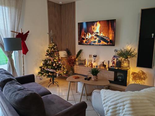 un salon avec un arbre de Noël et une cheminée dans l'établissement Gîte De L 'entre 2 Côtes, à Vindefontaine