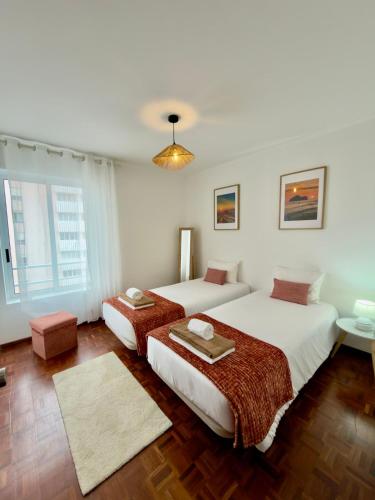 een slaapkamer met twee bedden en een raam bij City center Loreto in Ponta Delgada