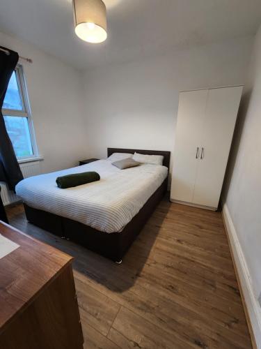 een slaapkamer met een bed en een witte kast bij The Oaks in Grays Thurrock
