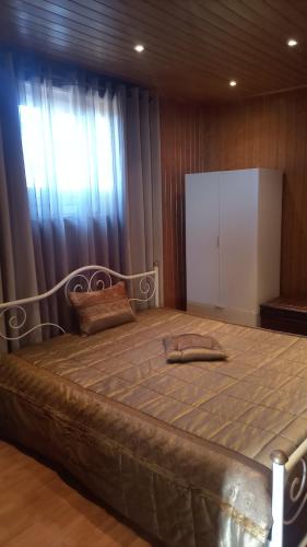 a large bed in a room with a window at Casa Rosàlia in Castro Daire