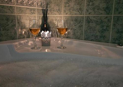 a tub with two glasses of wine and a bottle at Sielskie Sitno in Sitno