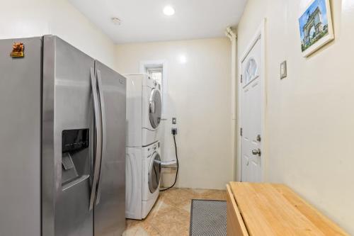 a kitchen with a stainless steel refrigerator and a table at Impeccable 1BR unit in Brooklyn in Brooklyn