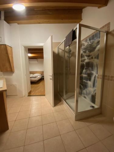 ein Bad mit einer Glasdusche im Zimmer in der Unterkunft Dolomiti Lodge - Fit & Well in Belluno