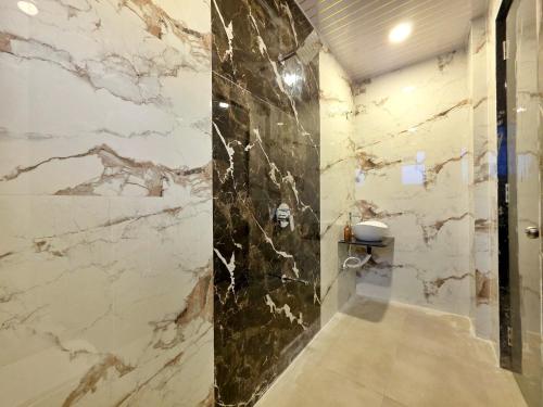 a bathroom with marble walls and a walk in shower at ll EMPYREAN STAYS ll G0DFATHER VILLA ll MASTERPIECE ll 4BHK ll AC ll LARGEST POOL ll in Lonavala