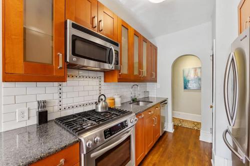a kitchen with wooden cabinets and a stove top oven at The Home Collection CLT: 500 Queens in Charlotte