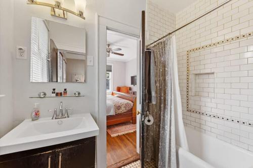 a bathroom with a sink and a tub and a bedroom at The Home Collection CLT: 500 Queens in Charlotte